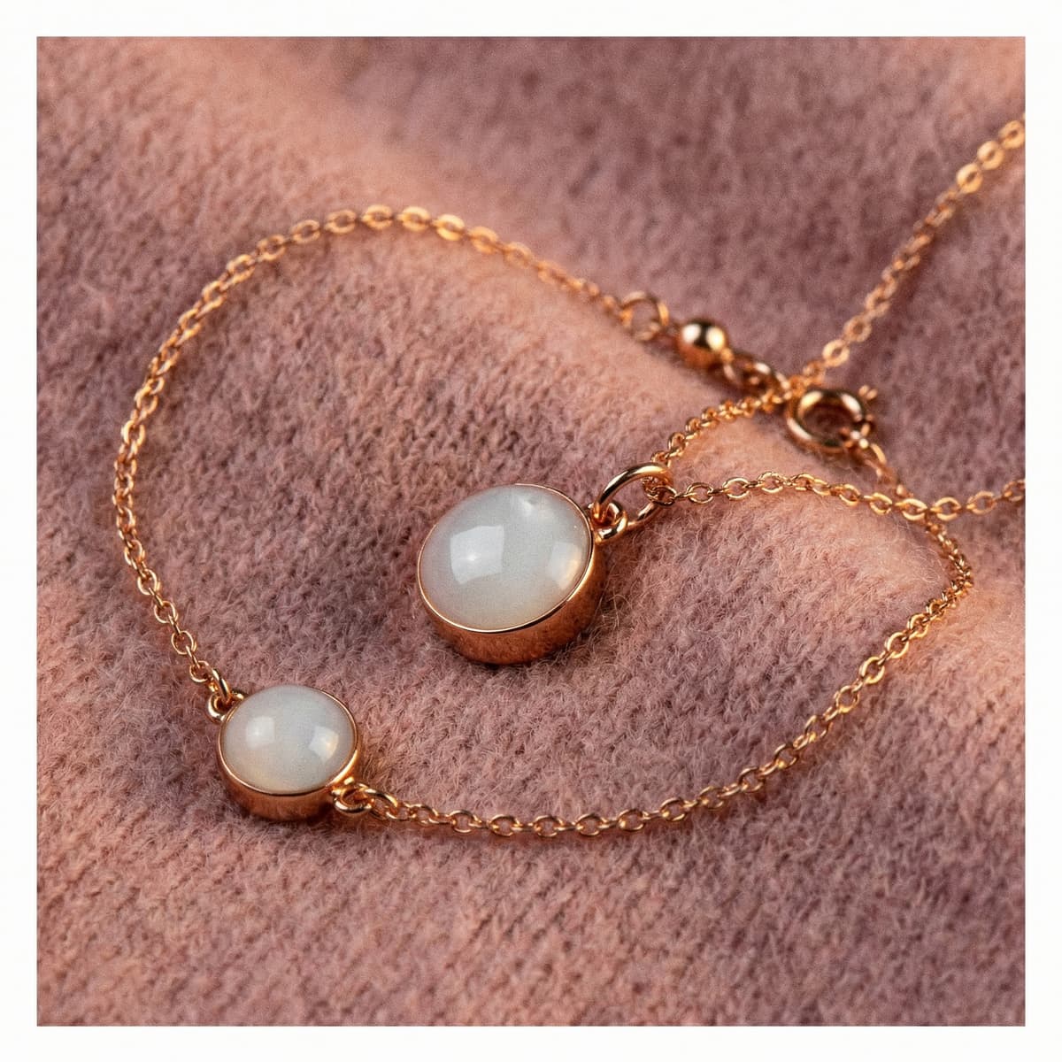 Rose-gold chain bracelet with two milky white breastmilk resin charms on soft pink fabric, a meaningful keepsake gift idea among the best push presents for new moms