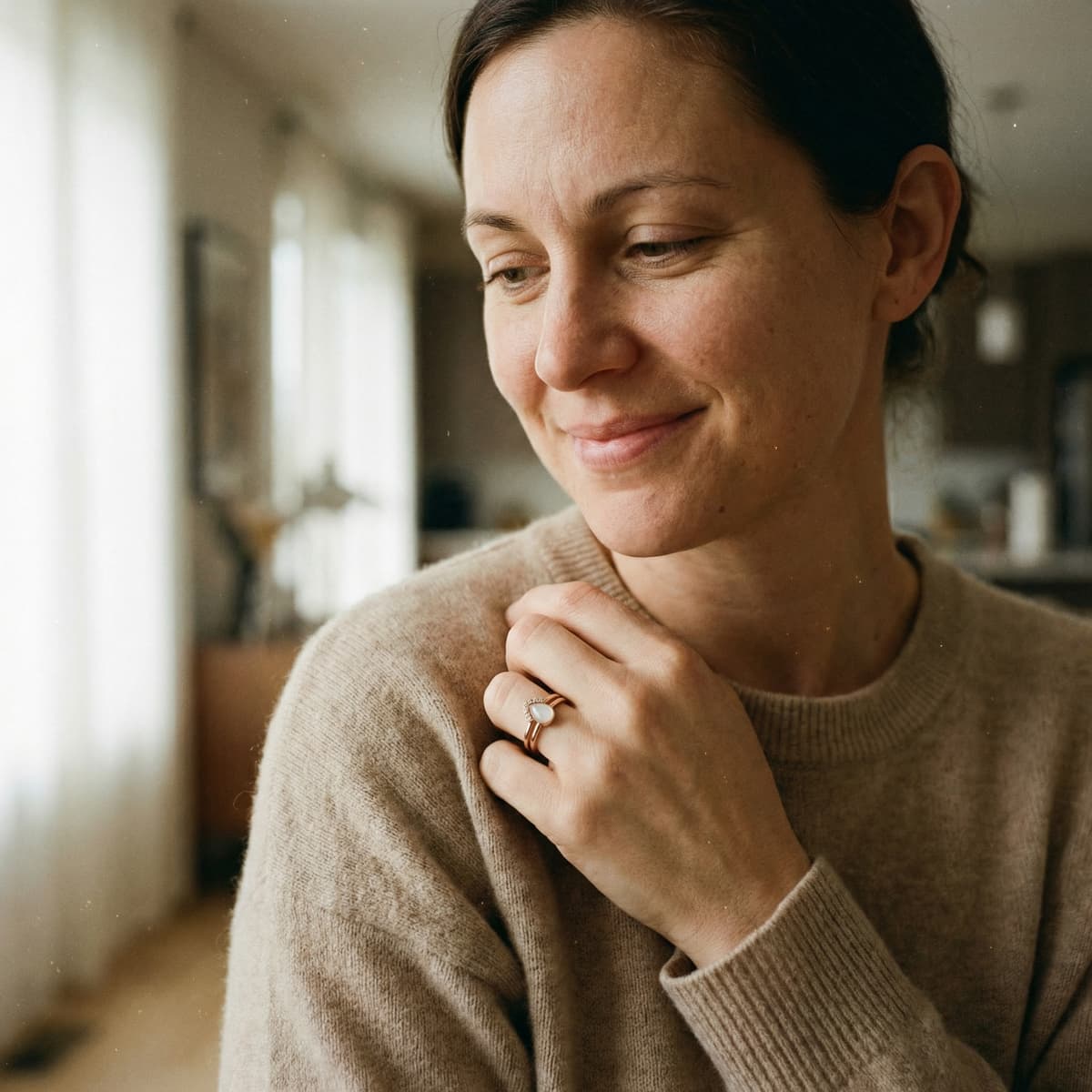 Smiling mother at home wearing a delicate breastmilk ring, showing why a breastmilk ring kit is a meaningful DIY choice for creating a personal keepsake.