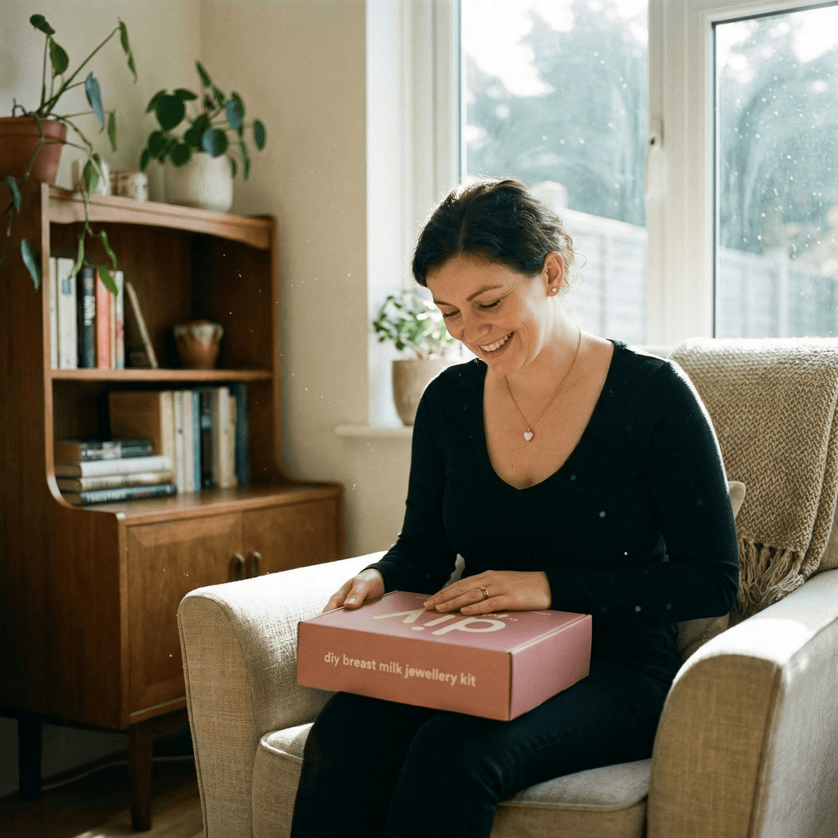 Smiling mom opening a DIY by MILKIES box at home, showing why a breastmilk jewelry diy making kit is an easy, private way to create a meaningful keepsake.