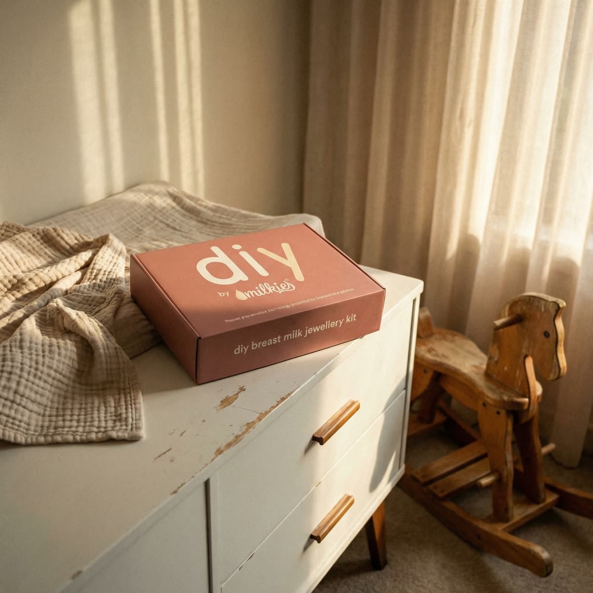 DIY by MILKIES breast milk jewellery kit box on a nursery dresser in warm sunlight, a thoughtful keepsake option among new mom gifts for pregnant women.